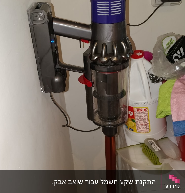 שואב אבק אלחוטי תלוי על הקיר עם כבל חשמל